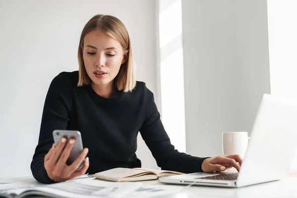 Business woman in office work with documents and phone. — Stok fotoğraf