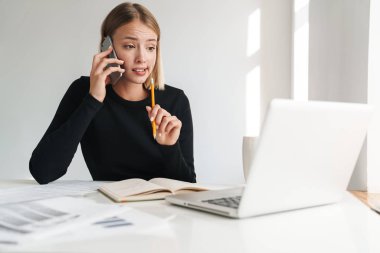 Confused young blonde business woman