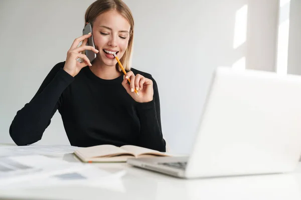 Smiling young blonde business woman talking by phone. — Stockfoto