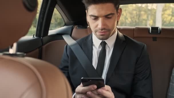 Hombre Negocios Guapo Concentrado Usando Teléfono Inteligente Mientras Está Sentado — Vídeo de stock