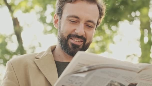 Homem Barbudo Elegante Feliz Jornal Leitura Revestimento Quando Sentado Parque — Vídeo de Stock