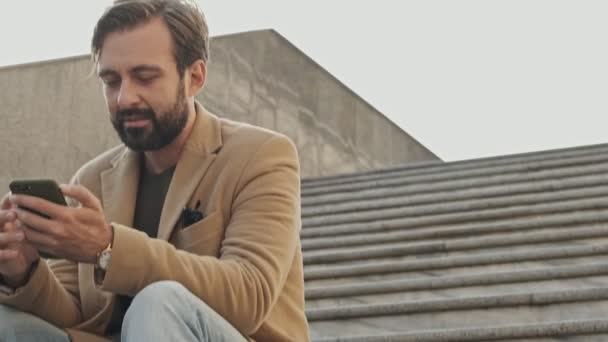 Vista Dal Basso Piacere Elegante Uomo Barbuto Cappotto Utilizzando Smartphone — Video Stock