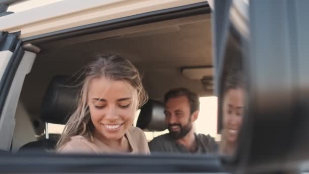 Uśmiechnięta Młoda Kobieta Siedzi Samochodzie Swoim Chłopakiem Psem Tylnym Siedzeniu — Wideo stockowe