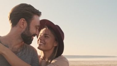 Olumlu gülümseyen genç bir çift, aşık bir adam ve kadın yazın gölün kenarında SUV arabasının yanında dururken sarılıyorlar. Kamera uzaklaşıyor.