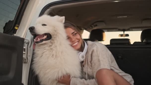 Een Glimlachende Positieve Jonge Vrouw Knuffelt Aaien Een Hond Kofferbak — Stockvideo