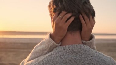 Şafak vakti gölün kenarında birbirlerine bakarken birbirlerine sarılmış genç bir çiftin yakın görüntüsü.