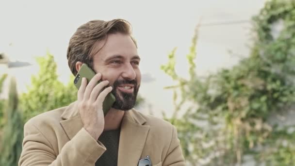 Feliz Hombre Barbudo Elegante Abrigo Hablando Por Teléfono Inteligente Mirando — Vídeo de stock