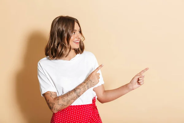 Image Brunette Woman Red Skirt Smiling Pointing Finger Copyspace Isolated — Stockfoto