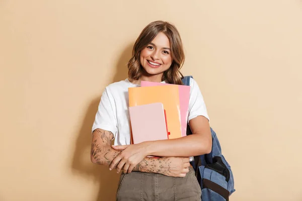 笑顔の女子高生の肖像バックパックを背景に孤立立って 教科書やコピー本を保持 — ストック写真