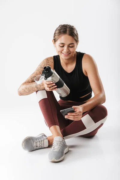 Image Happy Woman Sportswear Holding Cellphone Water Bottle While Sitting — Stockfoto