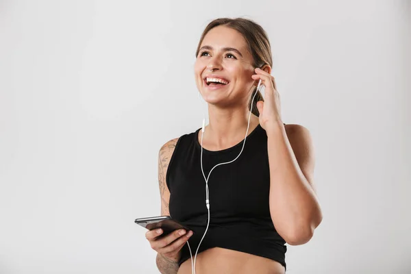 Image Caucasian Woman Sportswear Holding Smartphone Listening Music Earphones Isolated — Stockfoto