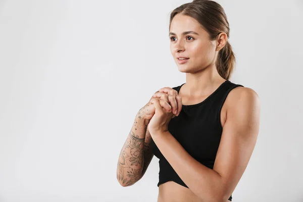 Foto Jovem Mulher Sportswear Esticando Braços Enquanto Fazia Exercício Isolado — Fotografia de Stock