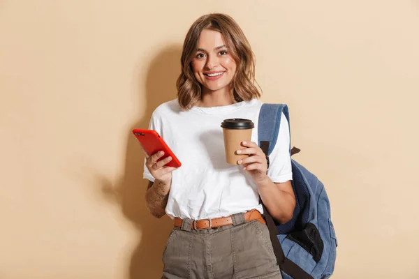 Afbeelding Van Stijlvolle Student Meisje Met Afhaalkoffie Kopje Smartphone Geïsoleerd — Stockfoto