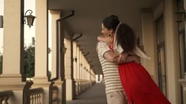 Kucaklaşan bir çift, sütunların etrafında dönerken flört ediyorlar.