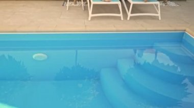 Sakin sakin bir çift, yaz aylarında yüzme havuzunun yanındaki terasta dinleniyor.