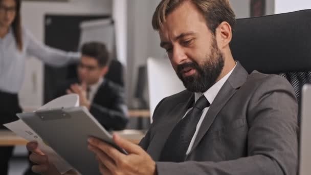 Hombre Negocios Pensativo Concentrado Traje Formal Sosteniendo Portapapeles Leyendo Documentos — Vídeo de stock