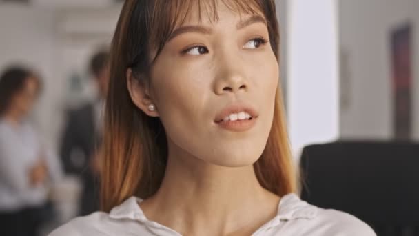 Close Widok Uśmiechnięta Azjatycka Businesswoman Rozglądając Się Podczas Stojąc Biurze — Wideo stockowe