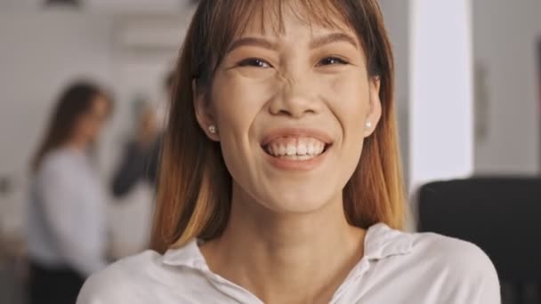 Ofiste Dikilirken Kameraya Bakıp Gülen Neşeli Asyalı Kadınının Yakın Görüntüsü — Stok video