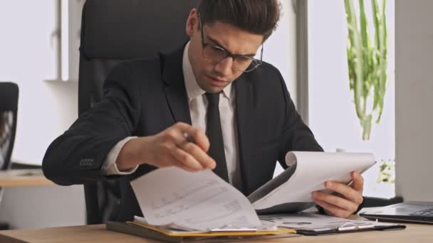 Homem Negócios Focado Terno Formal Óculos Estudando Documento Enquanto Sentado — Vídeo de Stock