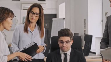 Açık planlı ofiste çalışırken masanın yakınındaki projeyi tartışan odaklanmış meslektaşlar