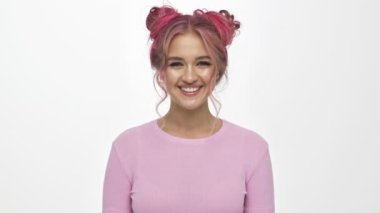 Renkli saç stili olan, kameraya gülümseyen ve gülen hoş bir genç kadın beyaz arka planda izole edilmiş.