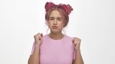 Renkli, pembe saç stili, beyaz arka planda izole edilmiş öfkesini gösteren güzel bir genç kadın.