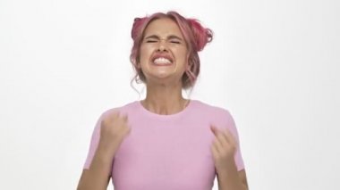 Renkli, pembe saçlı hoş bir bayan beyaz arka planda izole edilmiş bir jest yapıyor.