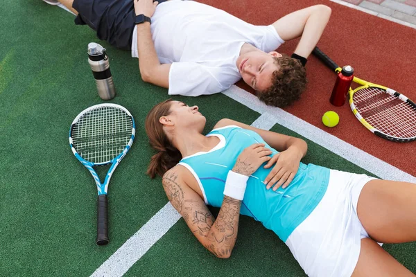 Imagem Jovem Mulher Sportswear Deitado Corte Com Raquetes Enquanto Joga — Fotografia de Stock