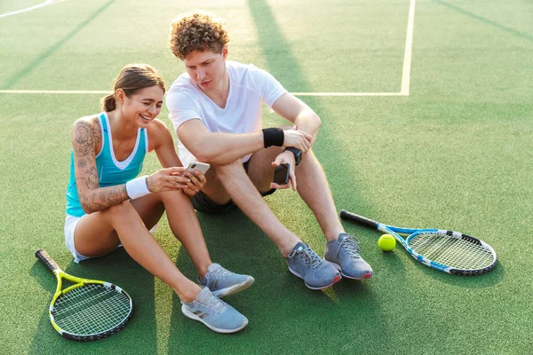 Aantrekkelijke Gezonde Tennissers Paar Met Behulp Van Mobiele Telefoons Tijdens — Stockfoto