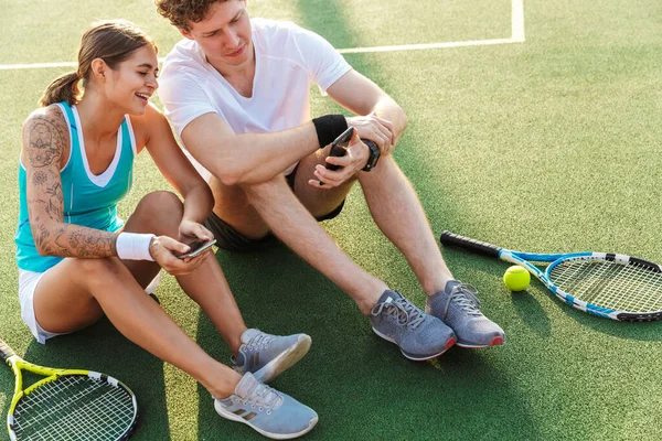 Vonzó Egészséges Teniszezők Pár Mobiltelefonnal Miközben Gyepen Stadionban — Stock Fotó