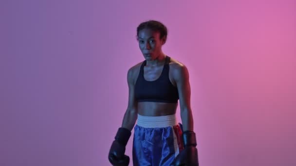 幸せなアフリカのスポーツ女性ボクサー喜びと下の隔離されたLed懐中電灯の背景を見ます — ストック動画