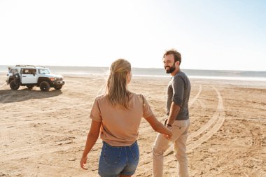 Sahildeki mutlu, iyimser, neşeli, harika, sevgi dolu çiftin görüntüsü..