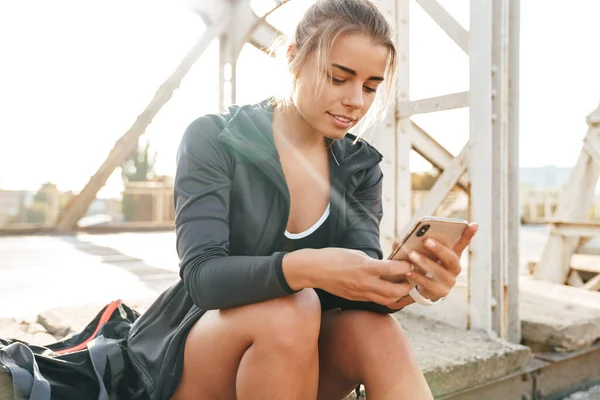 Prachtig Lachend Jong Sportmeisje Zittend Een Brug Luisterend Naar Muziek — Stockfoto