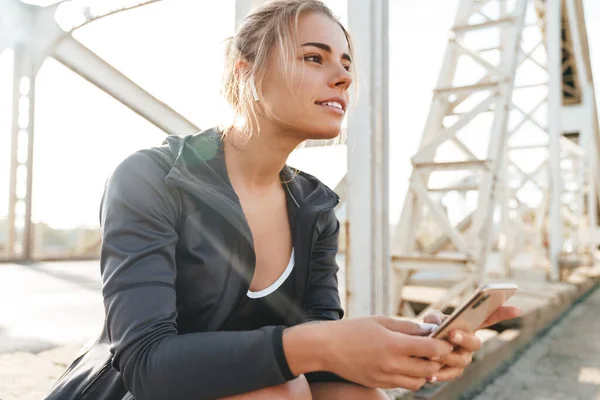 Bella Giovane Sportiva Sorridente Seduta Ponte Ascoltando Musica Con Gli — Foto Stock