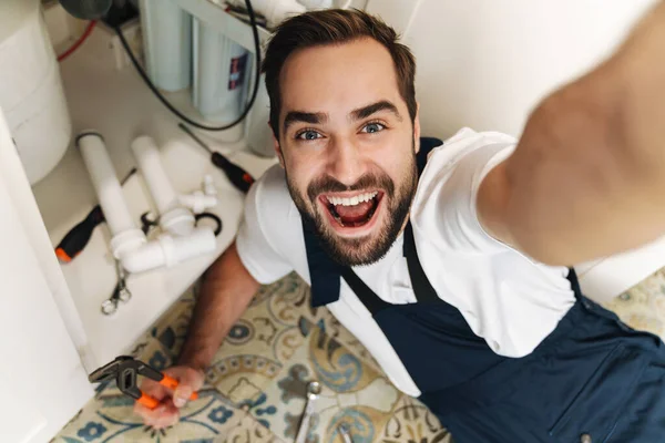 Imagem Jovem Otimista Feliz Encanador Trabalhar Uniforme Dentro Casa Tirar — Fotografia de Stock