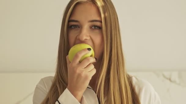 Güzel Genç Sarışın Bir Kadın Sabah Mutfakta Elma Yiyor — Stok video