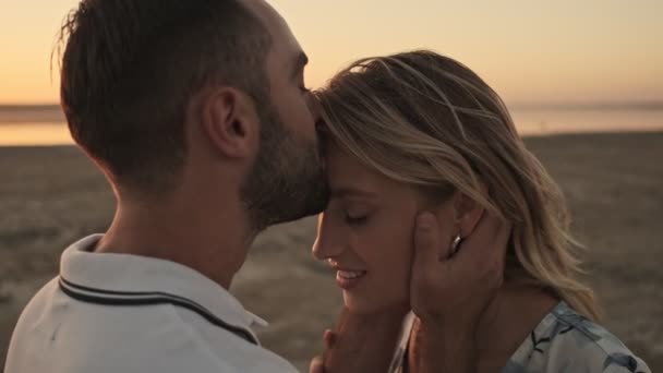 Hombre Guapo Besa Frente Una Chica Encantadora Playa Soleada Cerca — Vídeos de Stock