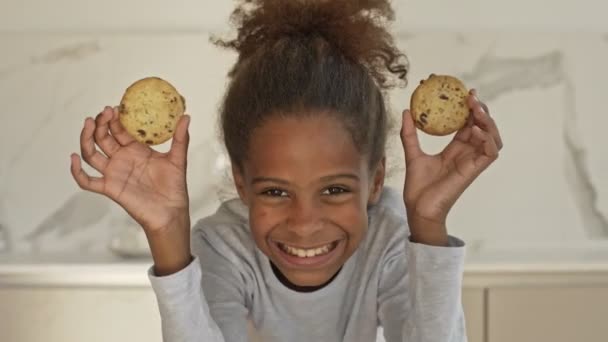 陽気なアフリカの女の子遊びとクッキーと見ますザカメラオンキッチン ホーム — ストック動画
