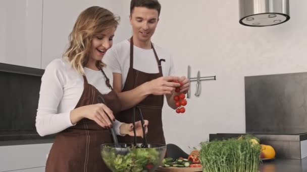 Lycklig Glad Ung Par Pojkvän Och Flickvän Lagar Sallad Tillsammans — Stockvideo