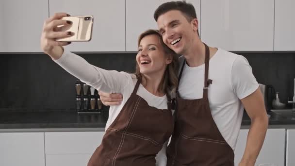 Cheerful Young Couple Man Woman Wearing Brown Aprons Taking Selfie — Stock Video