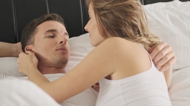 恋爱中快乐的年轻夫妇躺在白色的床上 在阳光灿烂的早晨享受蜜月 — 图库视频影像