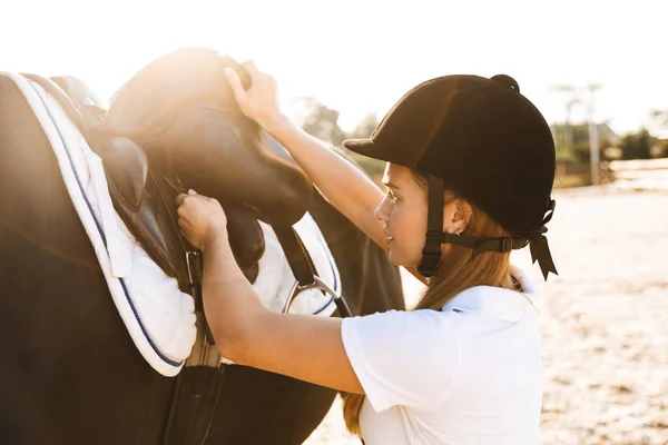 一个严肃而迷人的金发美女头戴帽子 骑着马站在户外的照片 — 图库照片
