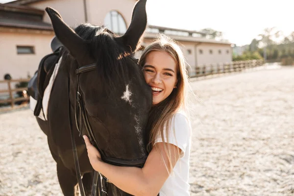 卡卡人快乐而积极的年轻金发美女与马在户外的形象 — 图库照片