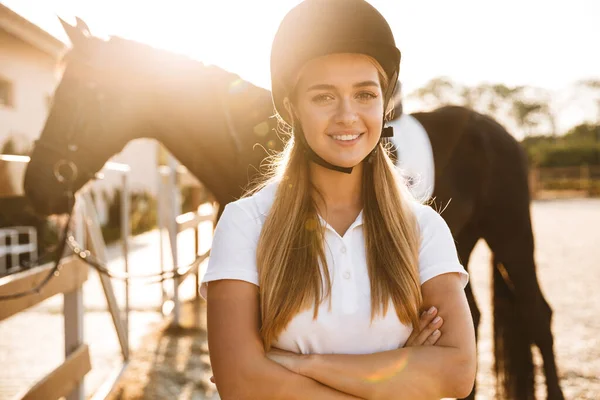 在户外 一个可爱的快乐快乐的年轻美丽女人头戴帽子 骑着马的照片 — 图库照片