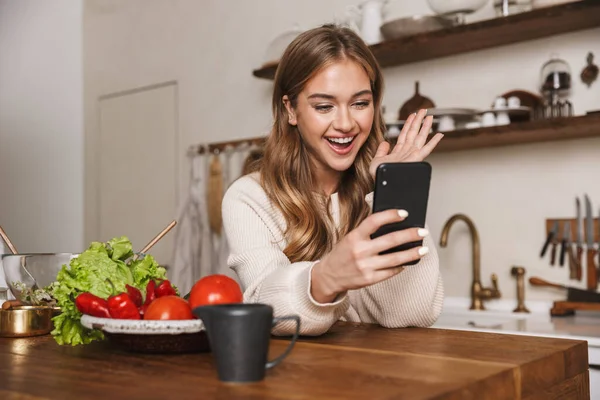 Kép Vidám Kaukázusi Visel Alkalmi Ruhák Segítségével Mobiltelefon Főzés Közben — Stock Fotó