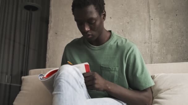 Een Serieuze Afro Amerikaanse Man Casual Kleding Maakt Aantekeningen Een — Stockvideo