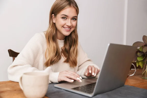Obraz Uśmiechniętej Białej Kobiety Noszącej Luźne Ubrania Przy Użyciu Laptopa — Zdjęcie stockowe