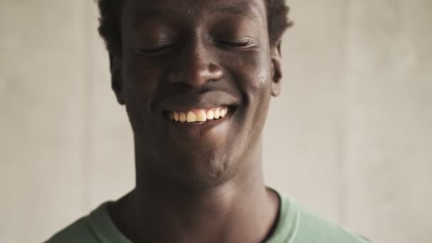 在灯光明亮的客厅里 一个积极英俊的非洲裔美国年轻人在镜头前笑了 — 图库视频影像