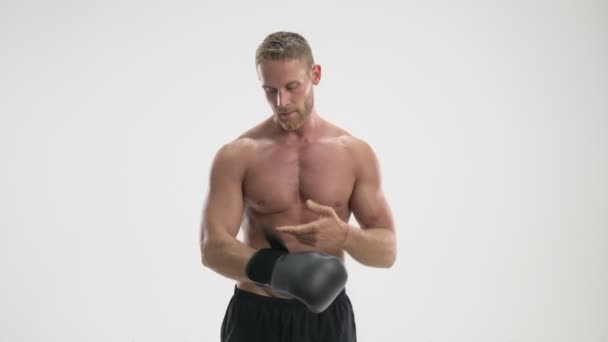 一位自信的年轻运动员戴上拳击手套 与白色背景隔离开来 — 图库视频影像
