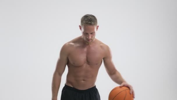 一个专注的年轻运动员 在白人背景下打篮球 — 图库视频影像